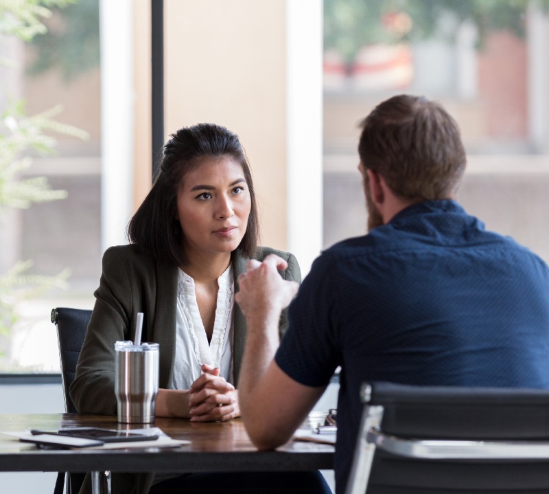 Een man en een vrouw hebben een gesprek aan een tafel