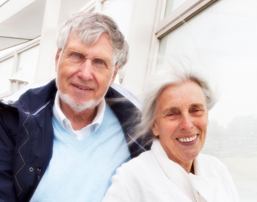 middelbaar echtpaar kijkt jou aan